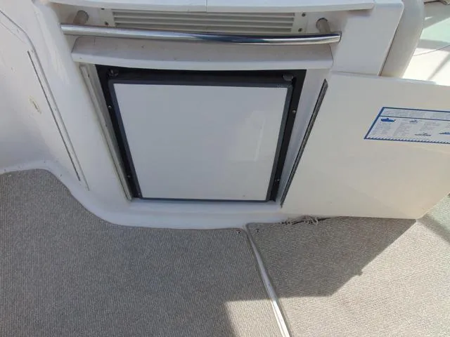 Slide: The Image of 2001 Chaparral 280SSi boat interior with built-in mini fridge and carpeted flooring. - 18