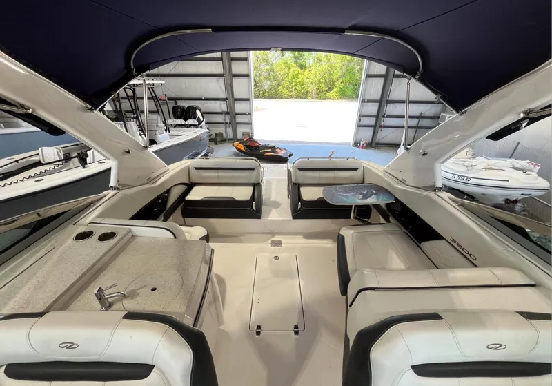 Slide: The Image of 2016 Regal 3200 Bowrider interior with spacious seating and canopy in a boat garage. - 10