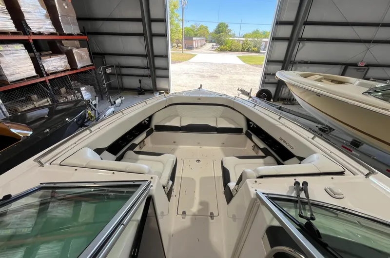 Slide: The Image of 2016 Regal 3200 Bowrider boat interior in storage, featuring spacious seating and open bow design. - 8