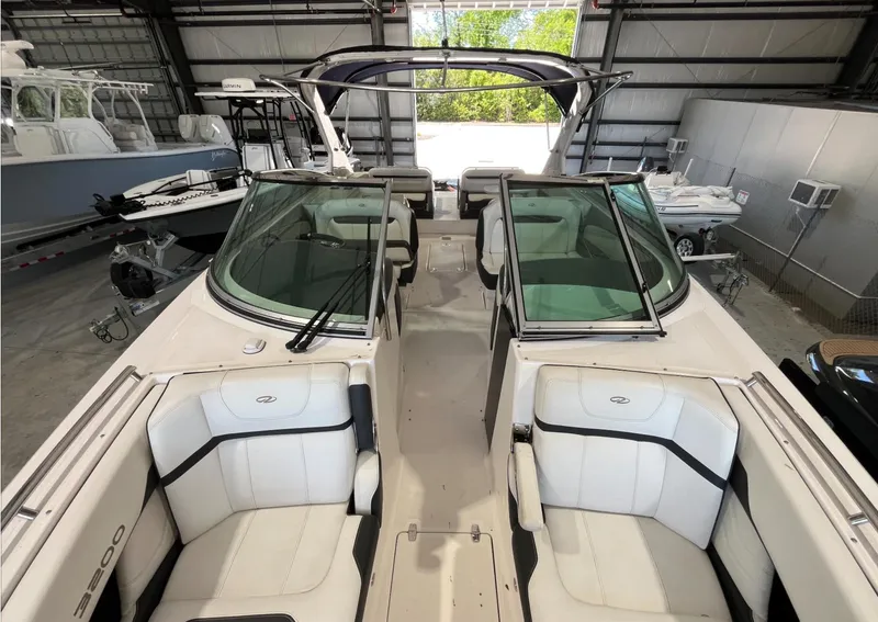 Slide: The Image of 2016 Regal 3200 Bowrider boat with white seating, stored indoors. - 9