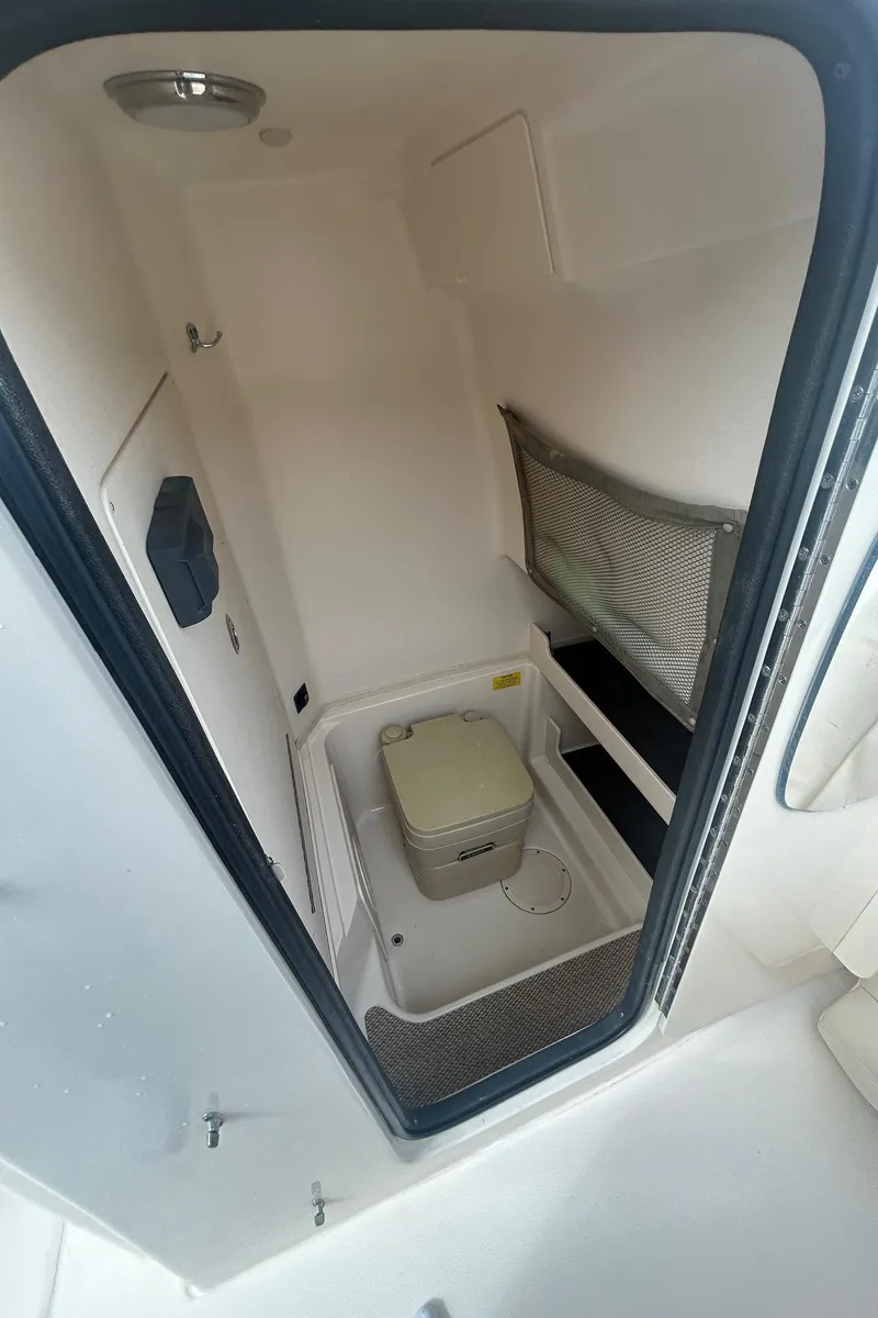 Slide: The Image of 2015 Grady-White Fisherman 257 boat with center console and T-top in a marina. - 16