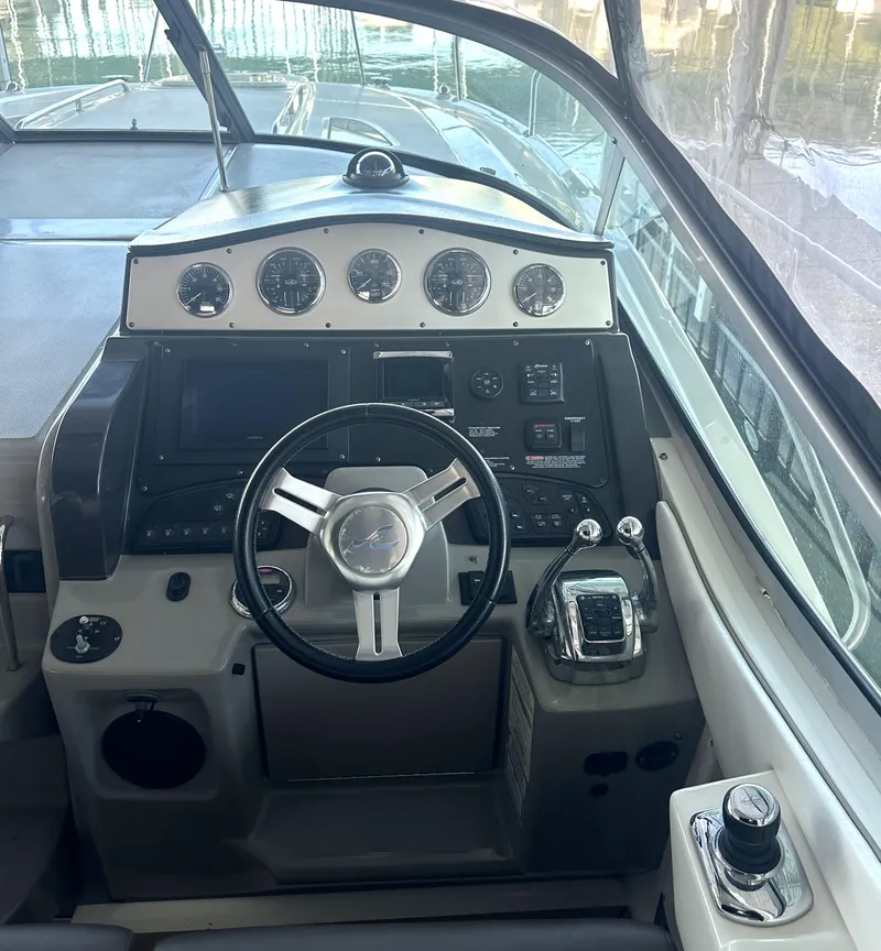 Slide: The Image of 2014 Sea Ray 330 Sundancer helm with steering wheel and control panel. - 11