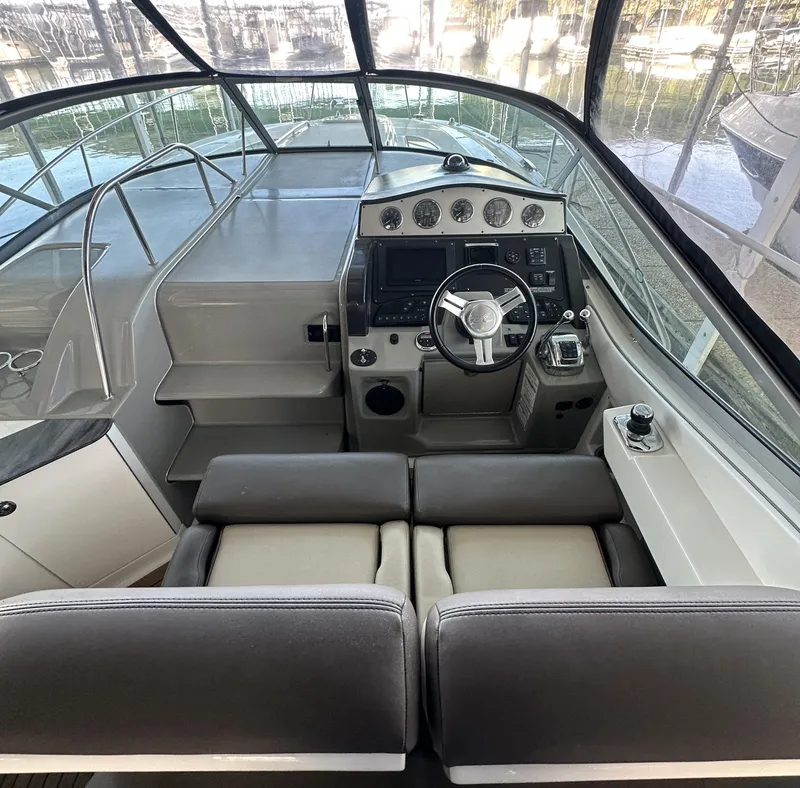 Slide: The Image of 2014 Sea Ray 330 Sundancer cockpit with steering wheel and control panel. - 12