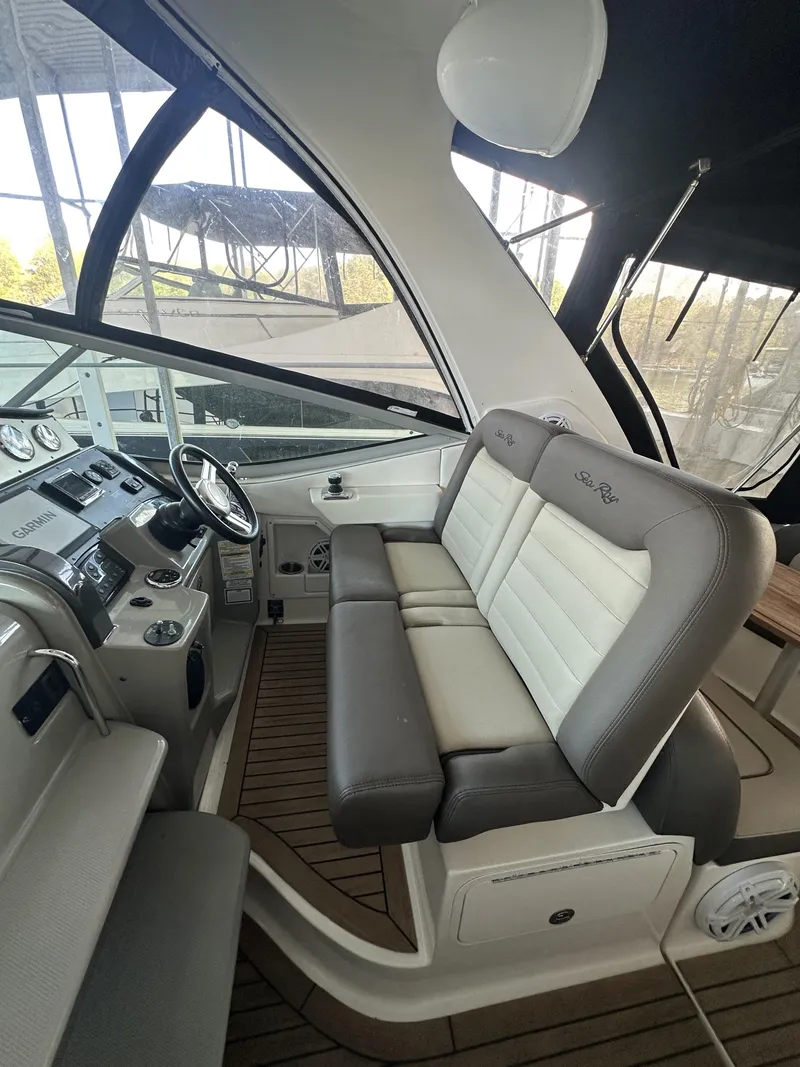Slide: The Image of 2014 Sea Ray 330 Sundancer cockpit with plush seating and modern dashboard. - 13