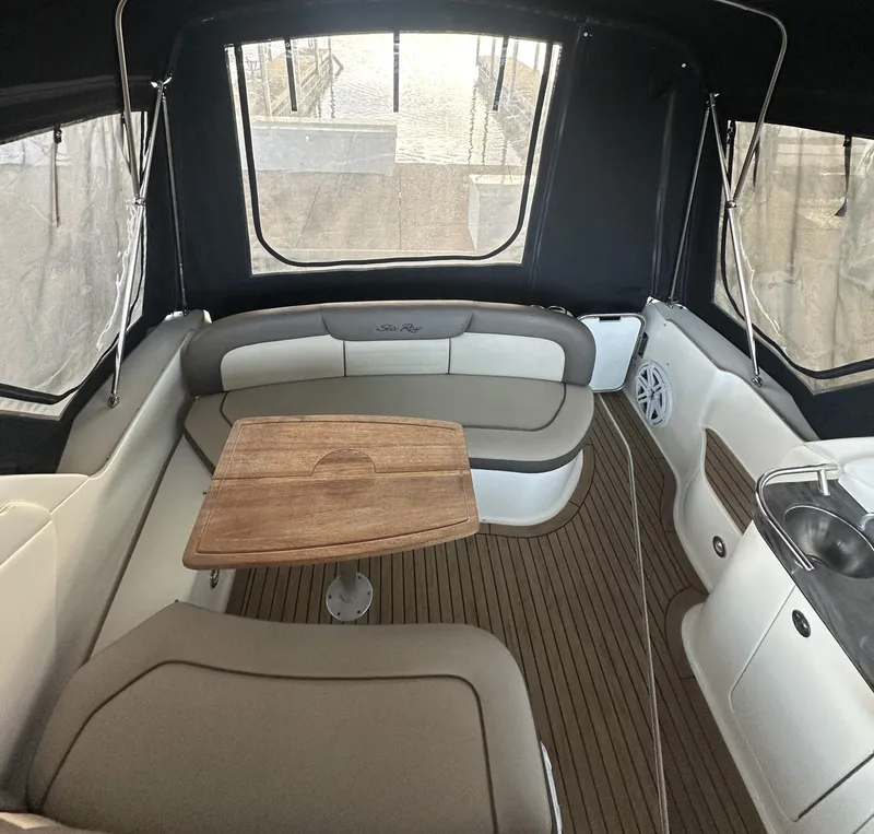 Slide: The Image of 2014 Sea Ray 330 Sundancer interior with seating, table, and kitchenette. - 14