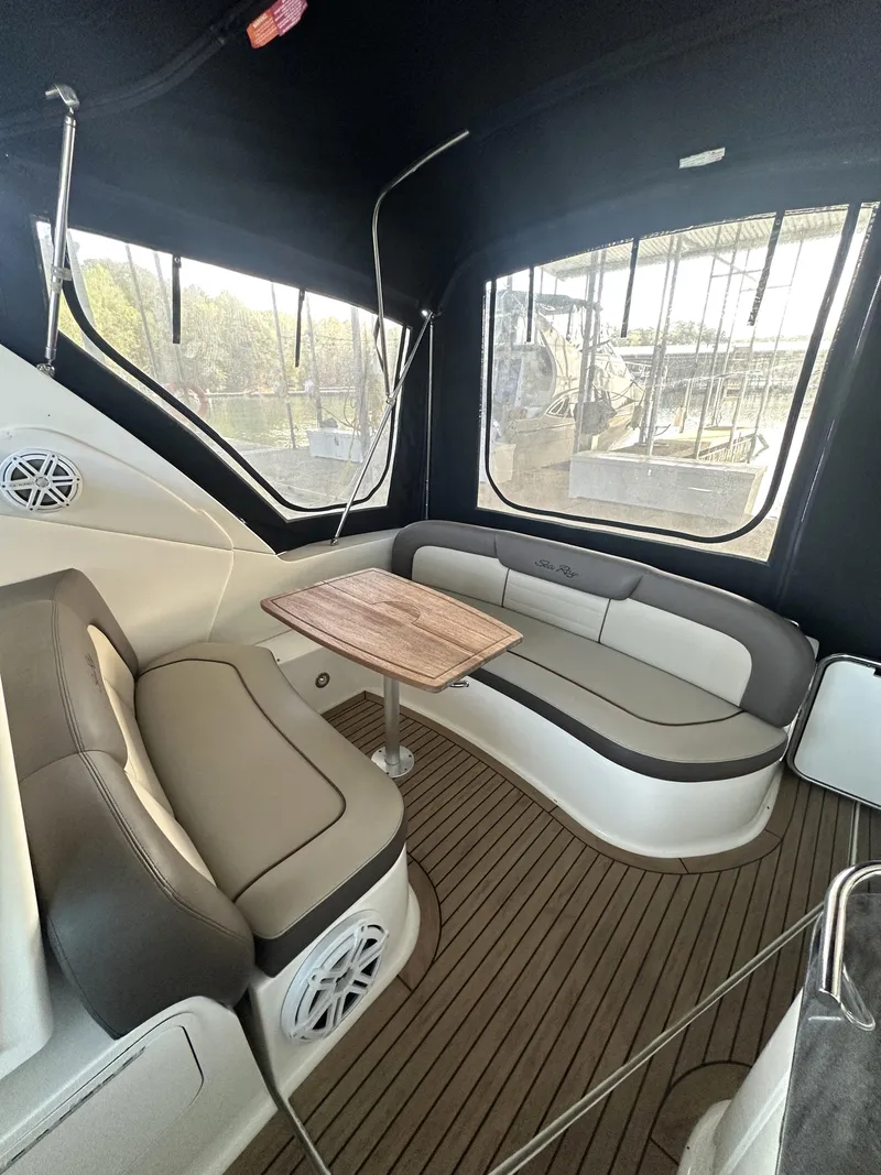 Slide: The Image of 2014 Sea Ray 330 Sundancer interior with seating and table, featuring sleek design and wood flooring. - 15