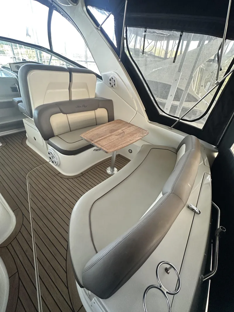 Slide: The Image of 2014 Sea Ray 330 Sundancer interior with seating and wooden table. - 18