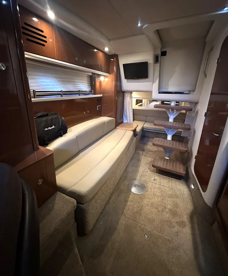 Slide: The Image of 2014 Sea Ray 330 Sundancer interior with seating, table, and TV. Luxurious yacht cabin design. - 20
