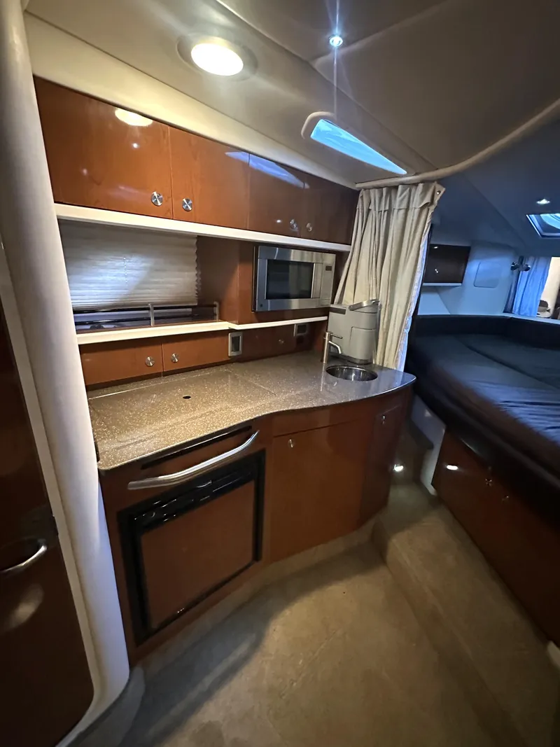 Slide: The Image of 2014 Sea Ray 330 Sundancer interior with kitchenette and sleeping area. - 23