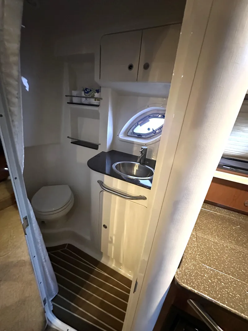 Slide: The Image of 2014 Sea Ray 330 Sundancer bathroom with sink, toilet, and storage shelves. - 24