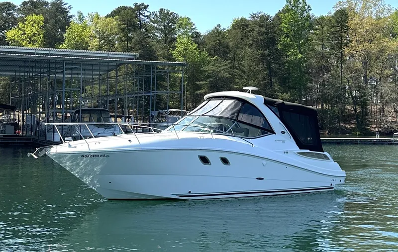 Slide: The Image of 2014 Sea Ray 330 Sundancer boat on a serene lake with lush trees in the background. - 3