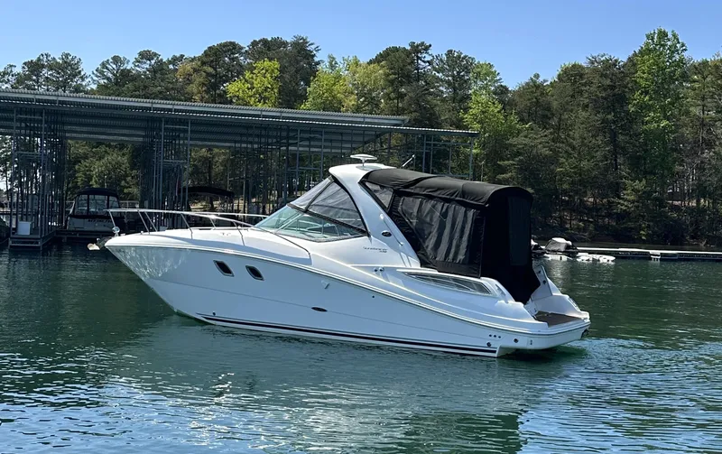 Slide: The Image of 2014 Sea Ray 330 Sundancer yacht on calm water near a marina. - 4