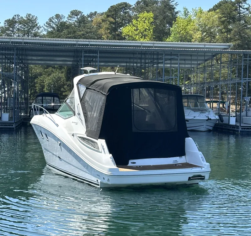 Slide: The Image of 2014 Sea Ray 330 Sundancer boat docked in a marina, rear view. - 5