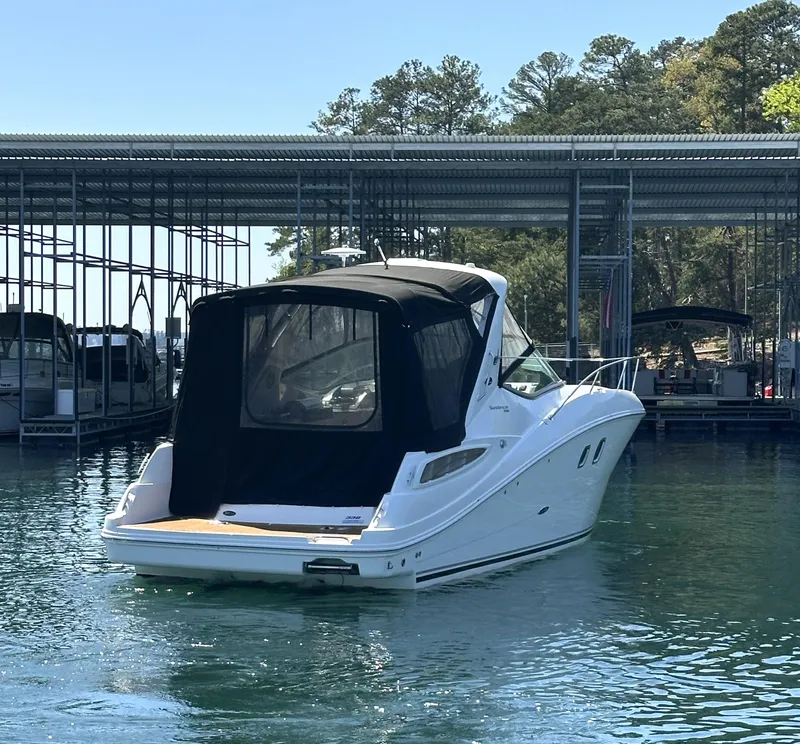 Slide: The Image of 2014 Sea Ray 330 Sundancer yacht docked in a marina, surrounded by calm water. - 6