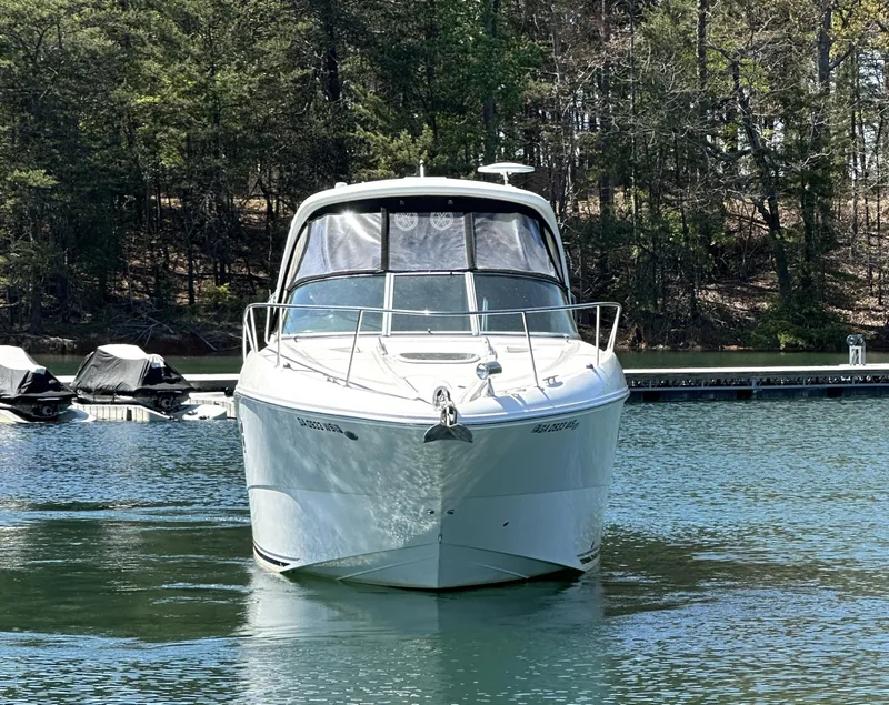 Slide: The Image of 2014 Sea Ray 330 Sundancer boat on a calm lake with forested background. - 7