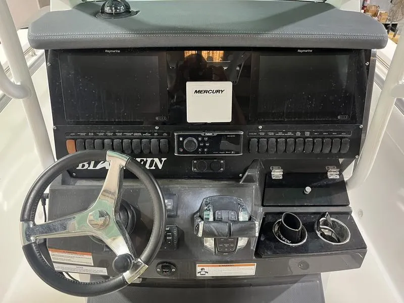 Slide: The Image of 2019 Blackfin 272 CC boat dashboard with steering wheel and Mercury controls. - 13