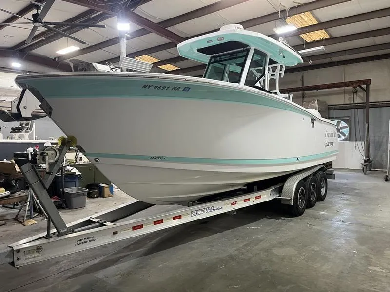 Slide: The Image of 2019 Blackfin 272 CC boat on a trailer in a warehouse setting. - 3