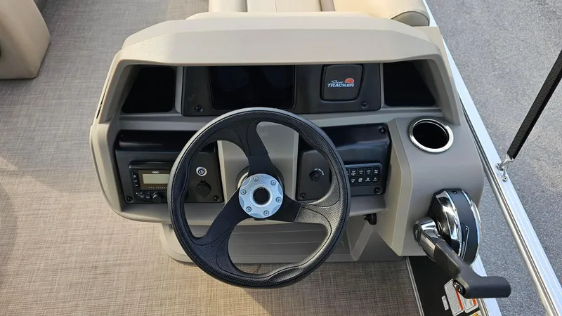 Slide: The Image of 2025 Sun Tracker Party Barge 18 DLX steering console with controls and cup holder. - 9