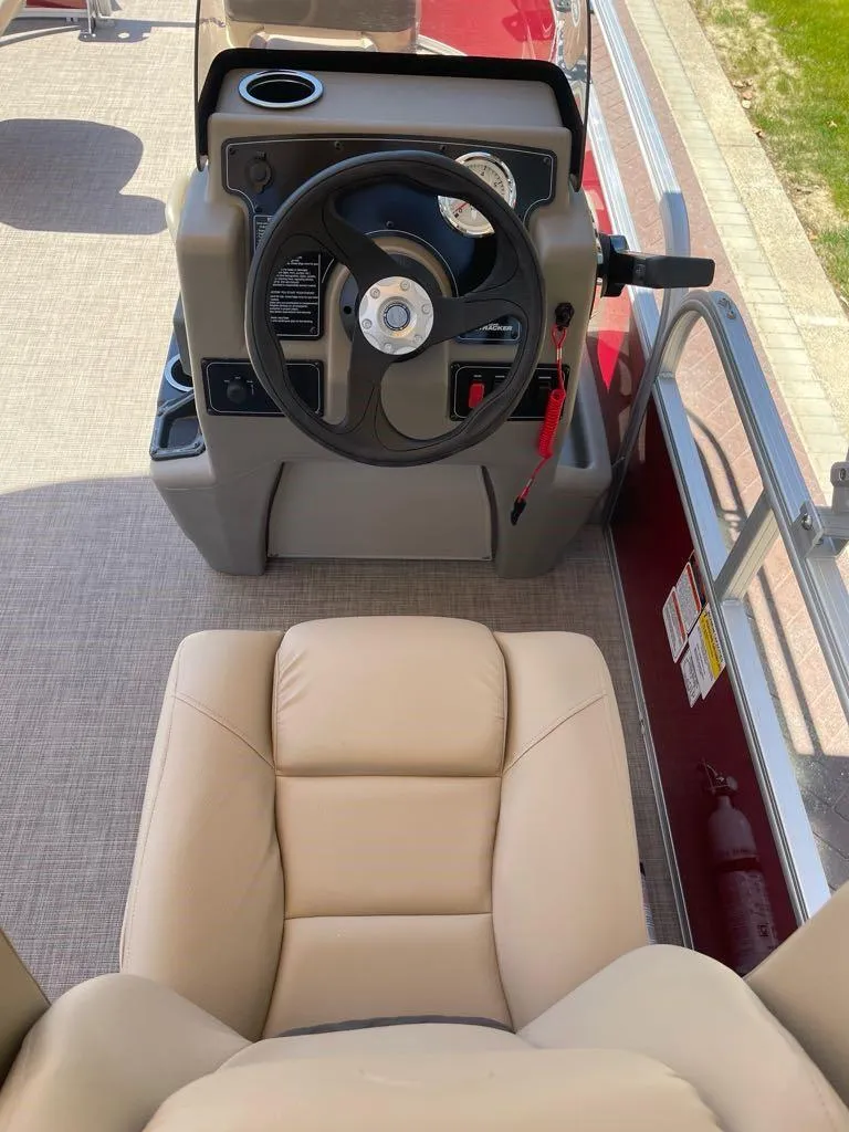 Slide: The Image of 2025 Sun Tracker Bass Buggy 16 XL Select steering console with beige seating. - 5