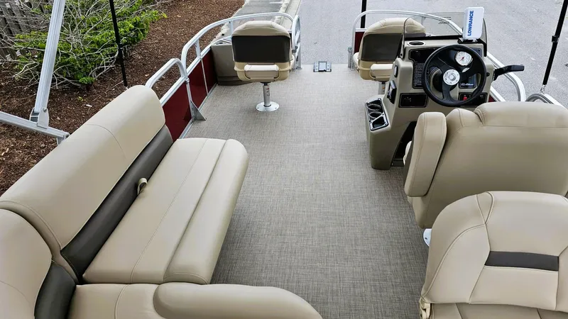 Slide: The Image of 2025 Sun Tracker Bass Buggy 18 DLX pontoon boat interior with beige seating and steering console. - 10