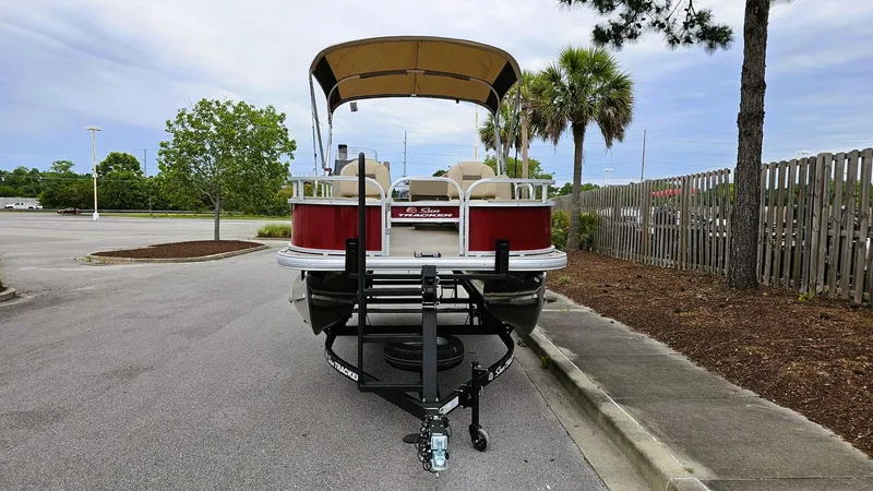 Slide: The Image of 2025 Sun Tracker Bass Buggy 18 DLX pontoon boat on trailer in parking lot. - 7