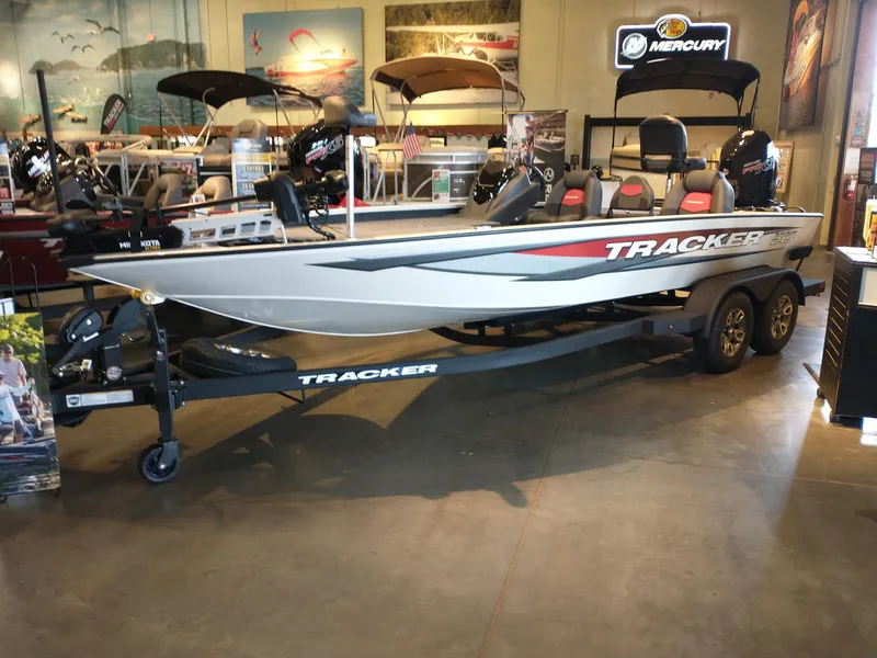 The Image of 2025 Tracker Savage 215 boat displayed in showroom with trailer and Mercury engine. - 0