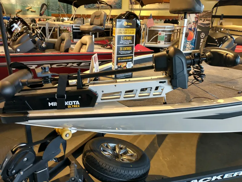 Slide: The Image of 2025 Tracker Savage 215 boat with Minn Kota Ultrex motor displayed indoors. - 3