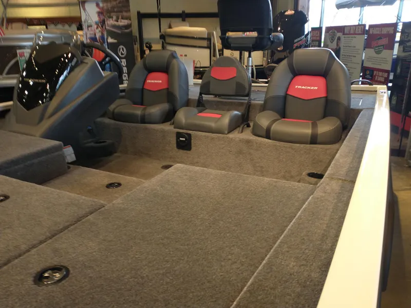 Slide: The Image of 2025 Tracker Savage 215 boat interior with gray and red seating, displayed indoors. - 8