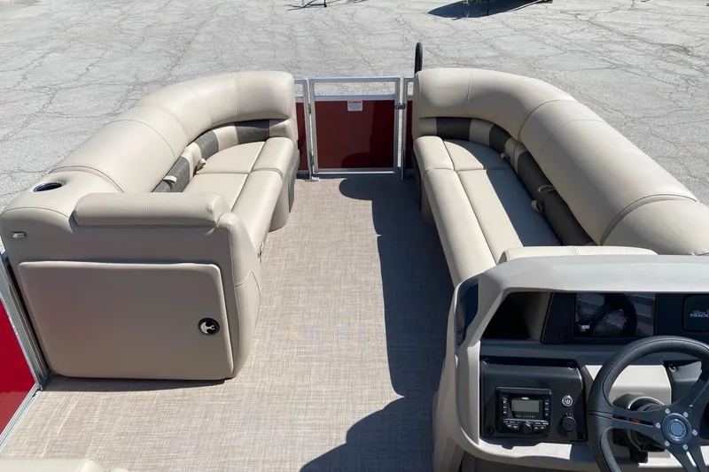 Slide: The Image of 2025 Sun Tracker Party Barge 20 DLX interior with beige seating and steering console. - 3
