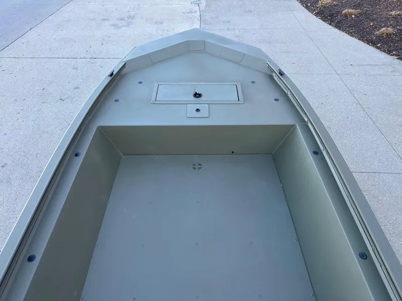 Slide: The Image of 2025 Tracker Grizzly 1648 Jon boat interior, showcasing spacious, durable design on concrete surface. - 3