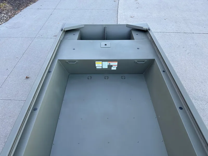 Slide: The Image of 2025 Tracker Grizzly 1648 Jon boat interior, showcasing spacious, durable design on concrete surface. - 4
