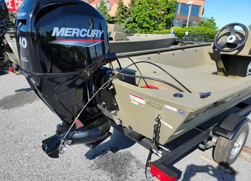 Slide: The Image of 2025 Tracker Grizzly 1648 SC boat with Mercury outboard motor, parked on a trailer. - 4