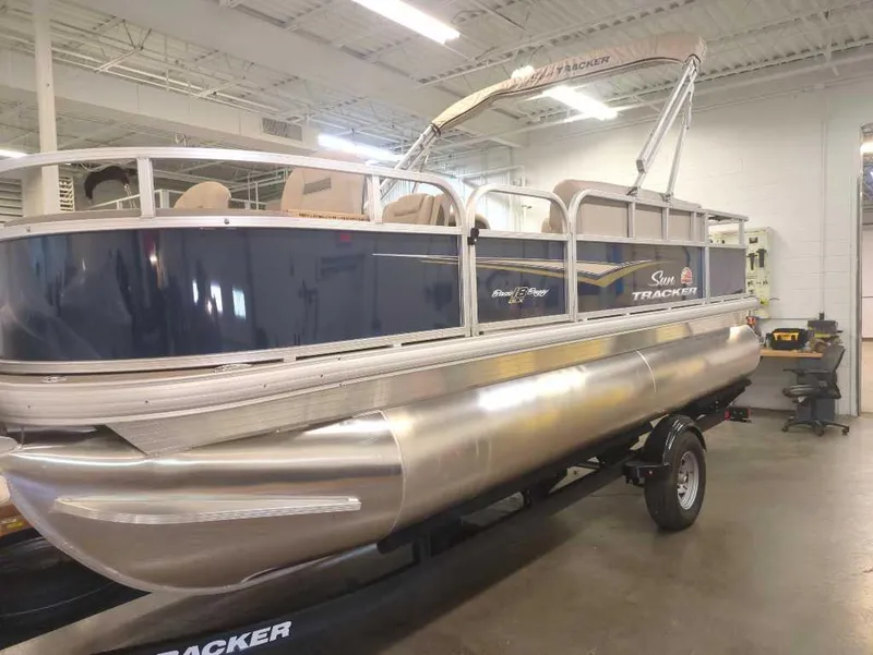 Slide: The Image of 2025 Sun Tracker Bass Buggy 18 DLX pontoon boat in a showroom setting. - 2