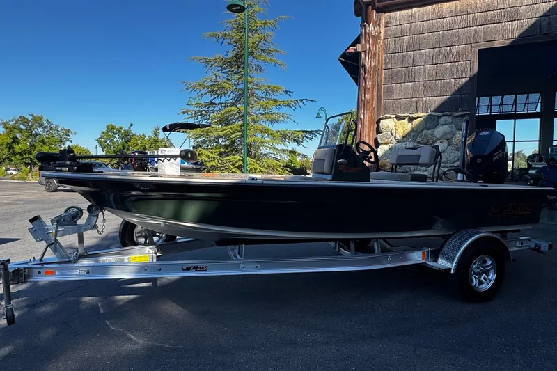 Slide: The Image of 2025 Mako 18 Pro Skiff Backwater Edition boat on trailer, parked outdoors. - 4