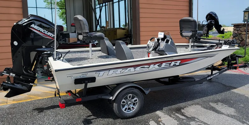Slide: The Image of 2025 Tracker Pro Team 175 boat with Mercury engine on trailer, parked outdoors. - 4