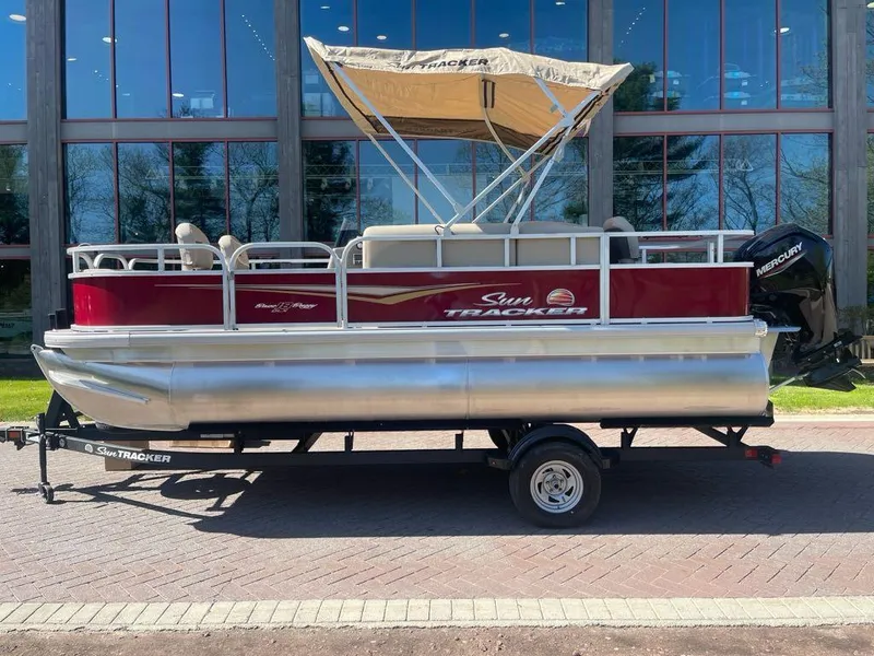 The Image of 2025 Sun Tracker Bass Buggy 18 DLX pontoon boat with canopy on trailer. - 0