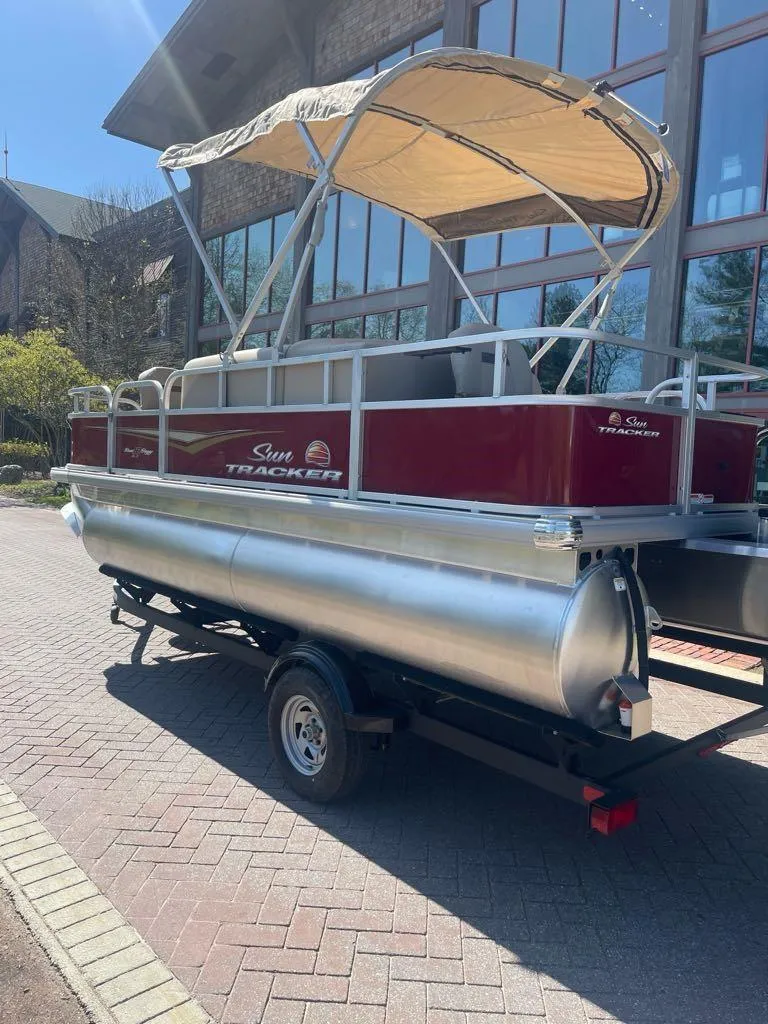 Slide: The Image of 2025 Sun Tracker Bass Buggy 18 DLX pontoon boat with canopy on trailer. - 3