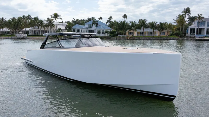 The Image of 2024 VanDutch 56 yacht on serene water, with luxury waterfront homes in the background. - 0