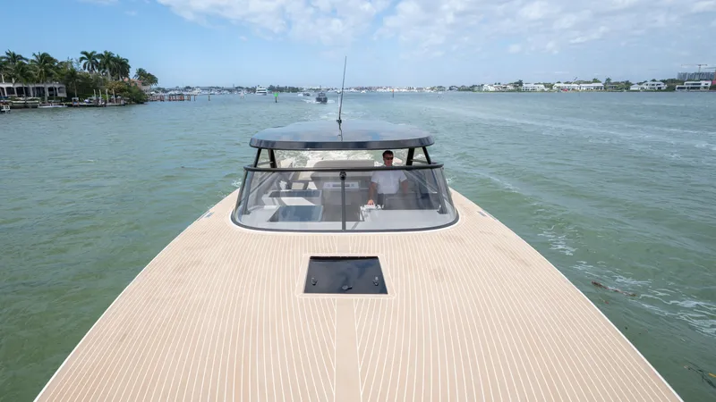 Slide: The Image of 2024 VanDutch 56 yacht cruising on a calm waterway under a partly cloudy sky. - 18