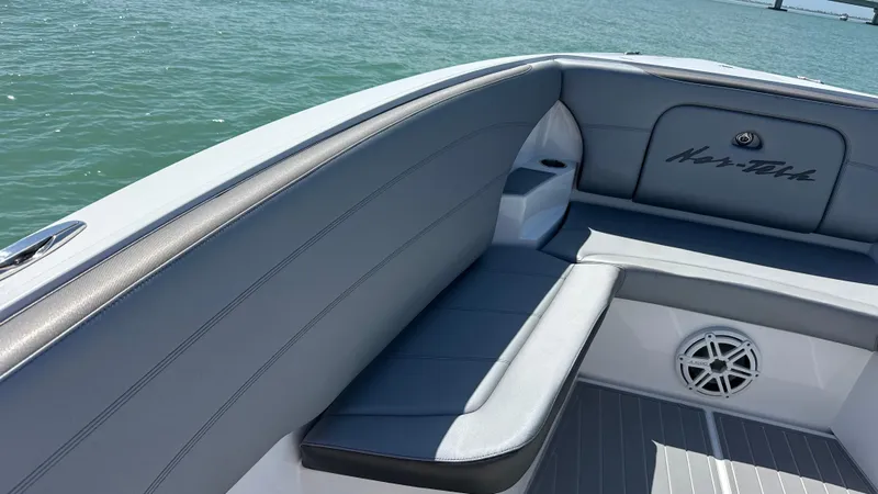 Slide: The Image of 2018 Nor-Tech 340 Sport Center Console boat interior with gray seating and speaker. - 10
