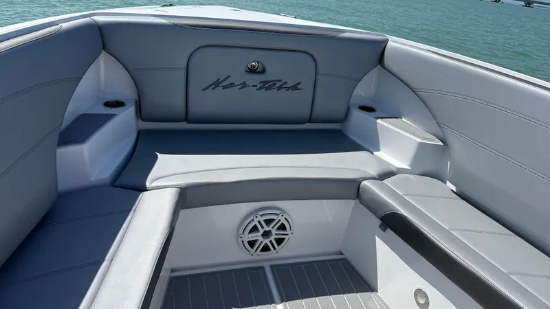 Slide: The Image of 2018 Nor-Tech 340 Sport Center Console boat interior with gray seating and speaker. - 12