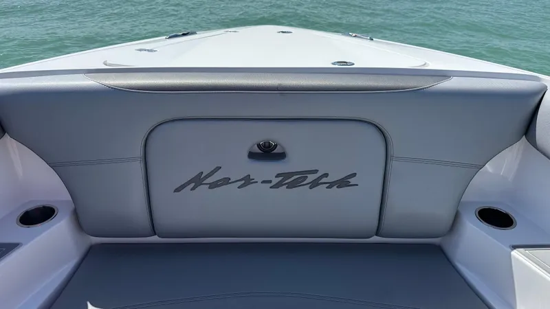 Slide: The Image of 2018 Nor-Tech 340 Sport Center Console boat interior with logo, on calm water. - 13