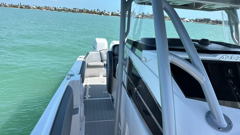 Slide: The Image of 2018 Nor-Tech 340 Sport Center Console boat on calm turquoise water. - 19