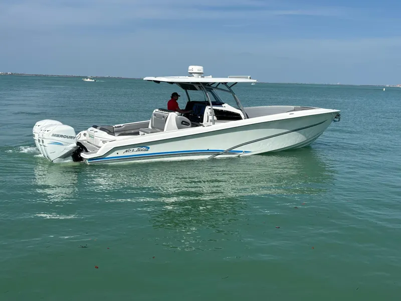 Slide: The Image of 2018 Nor-Tech 340 Sport Center Console boat on calm water, side view. - 5