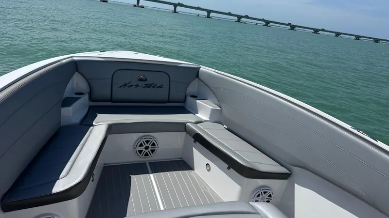 Slide: The Image of 2018 Nor-Tech 340 Sport Center Console boat interior with gray seating on calm water. - 9