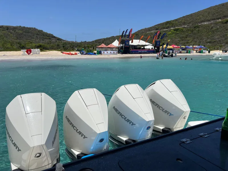 Slide: The Image of Four Mercury outboard engines on a 2021 Boston Whaler 405 Conquest near a scenic beach. - 6