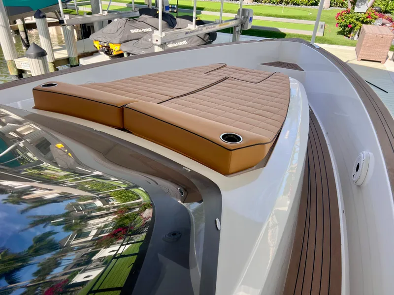 Slide: The Image of 2024 Pardo Yachts P38 with brown cushioned deck, docked near greenery. - 18