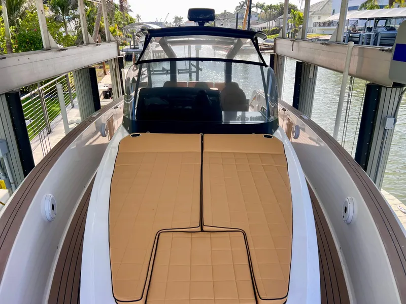 Slide: The Image of 2024 Pardo Yachts P38 with tan deck cushions, docked in a marina. - 19