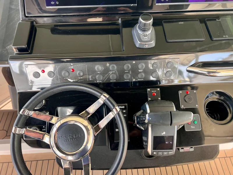 Slide: The Image of 2024 Pardo Yachts P38 helm with steering wheel, controls, and navigation instruments. - 6