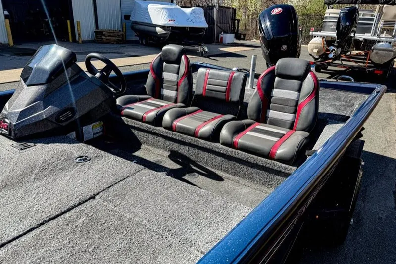 Slide: The Image of 2021 Ranger RT188P boat interior with three seats, steering console, and motor in a marina setting. - 2